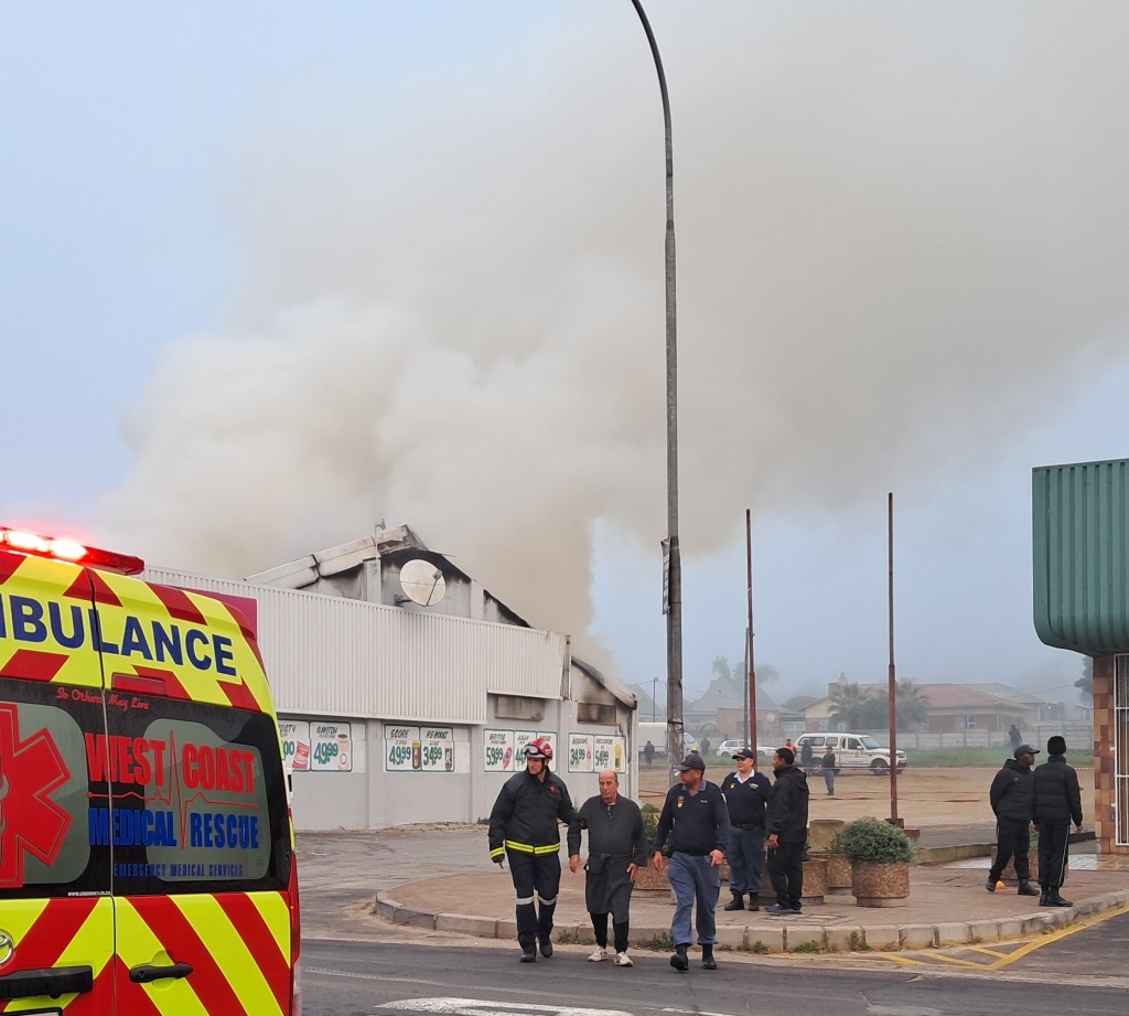 West Coast Medical Rescue-personeel begelei die eienaar van die gebou na ’n ambulans . FOTO: Alida Buckle