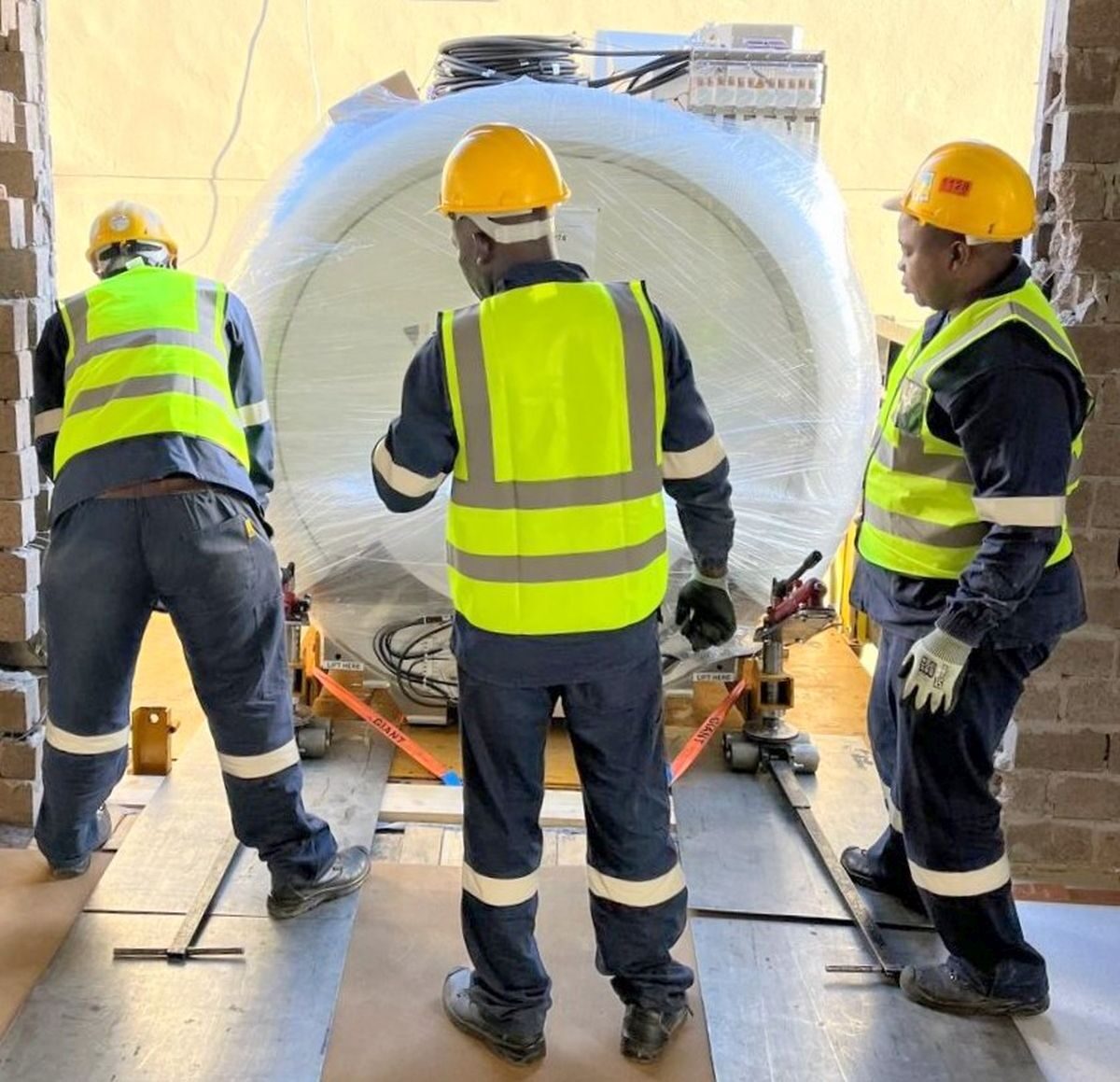 Technical teams carefully manoeuvre the new low-helium MRI system into position.