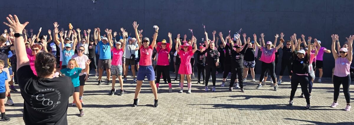 Deelnemers warm op vir die 5km-stap en -draf ter ondersteuning van borskankerbewustheid.