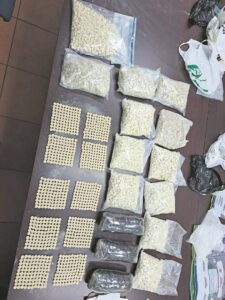 Woman arrested after drugs, ammo found in flat