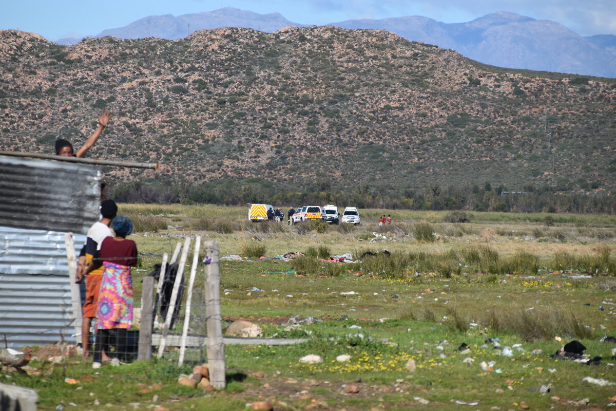 Polisievoertuie op die toneel waar menslike oorskot gevind is