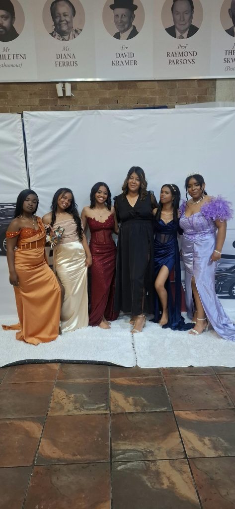 Cherise Kock (links), Lynnre Mounton, Zoe Daames, J.C Brown (onderwyseres), Wilmay Afrika, Micaela Apollis van Esselenpark Senior Sekondêr glimlag vir die kamera voor die aand begin.