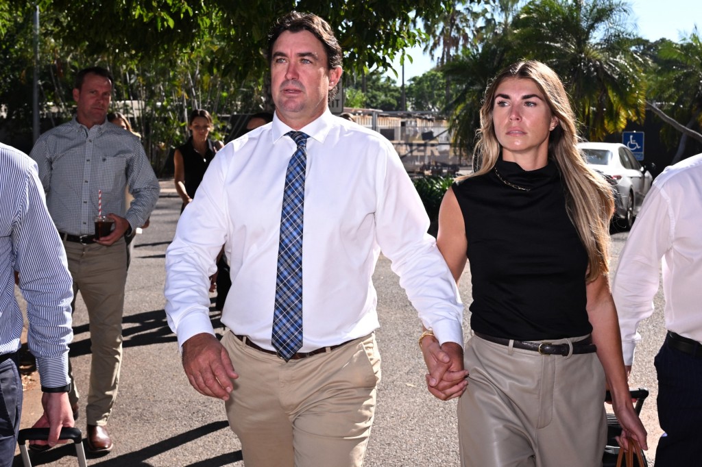 Matt Wright (L), the star of Netflix show Wild Croc Territory and National Geographic's Outback Wrangler, arrives with his wife Kaia Wright (R) at the Supreme Court in Darwin on August 12, 2025. Wright has pleaded not guilty to three charges of attempting to pervert the course of justice by his alleged actions after the fatal helicopter crash on February 28, 2022 that killed his friend and Netflix co-star Chris “Willow” Wilson during an operation to collect crocodile eggs around the King River in Arnhem Land in 2022. (Photo by William WEST / AFP)