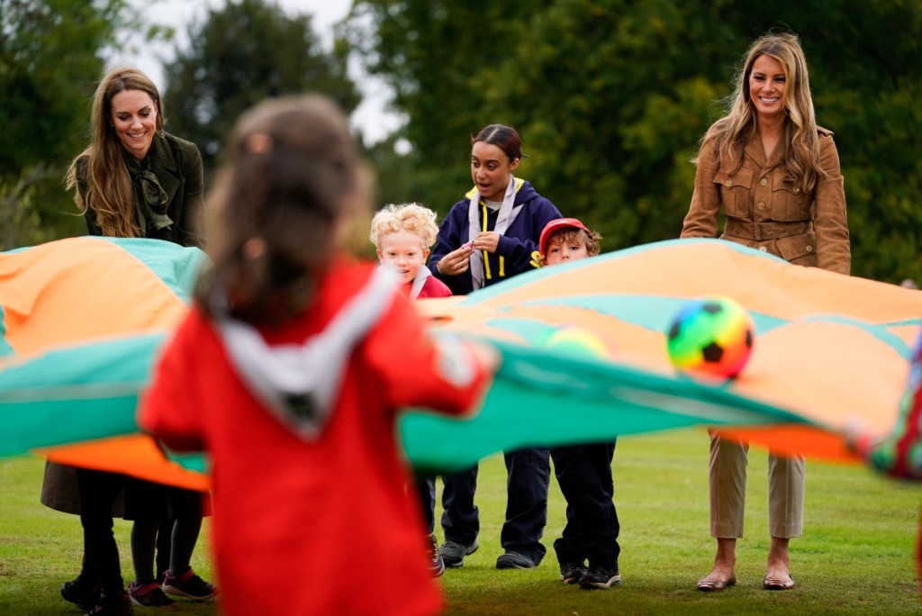 US First Lady Melania Trump and Britain's Catherine, Princess of Wales shake a parachute filled with balls with a group of Squirrels from the Scout Association at Frogmore Cottage on the Windsor Estate, in Windsor, on September 18, 2025, during the second State Visit of US President Donald Trump. (Photo by Nathan Howard / POOL / AFP)