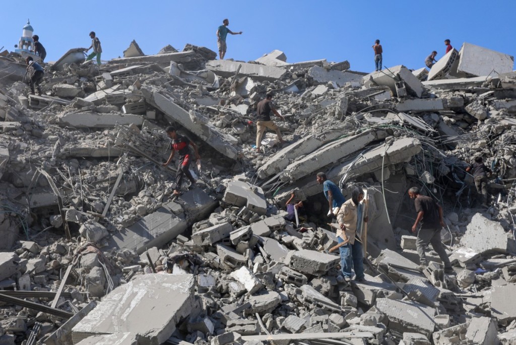 Palestinians search the rubble of al-Ghafari tower after its destruction by Israeli airstrikes in Gaza City on September 15, 2025. Israel's military had said on September 9 that it will act with "great force" in Gaza City and ordered residents to leave as it stepped up a deadly assault on the Palestinian territory's largest urban centre. (Photo by Omar AL-Qattaa / AFP)