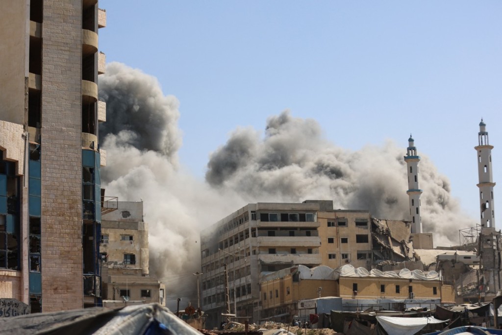 Smoke billows as Israeli airstrikes destroy the al-Ghafari tower in Gaza City. (Photo by Omar AL-Qattaa / AFP)