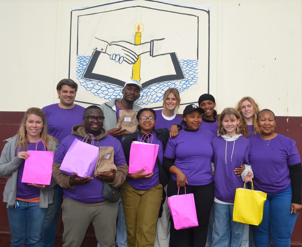 A group of people holding up gift bags.