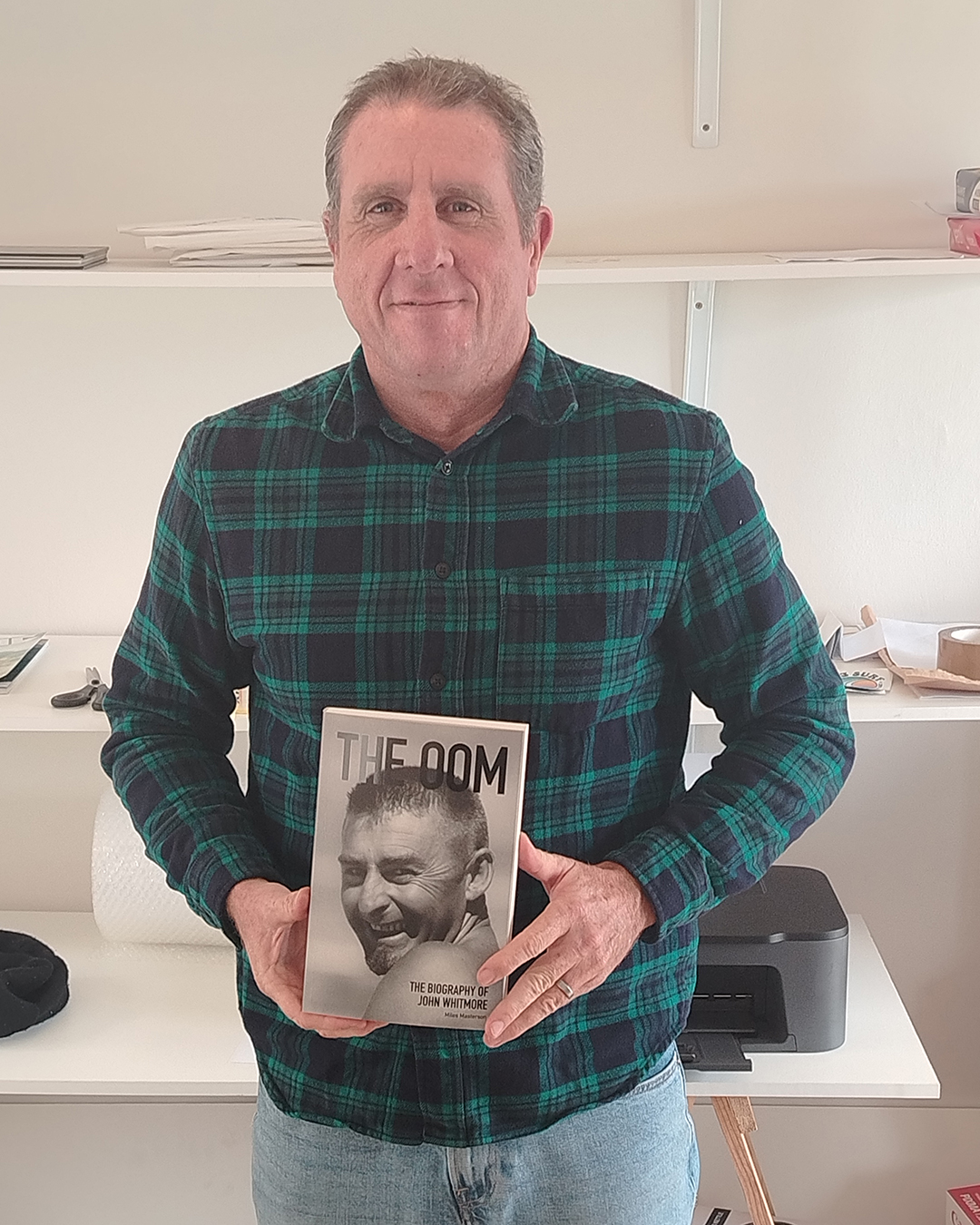 Author Miles Masterson holding his new book