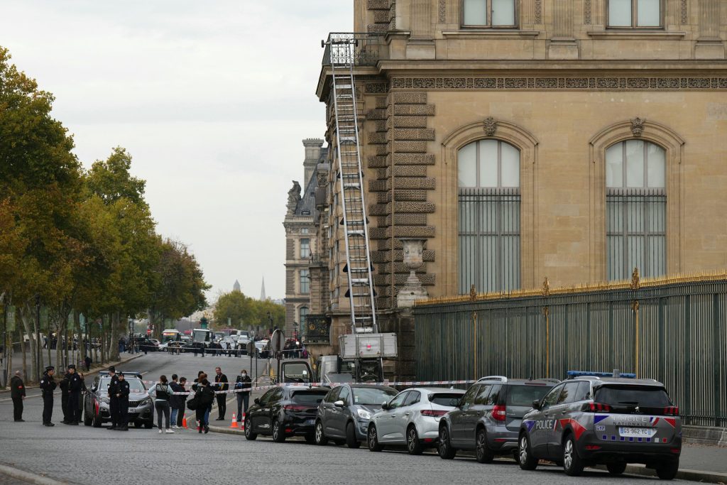 French police officers stand next to a furniture elevator used by robbers to enter the Louvre Museum in Paris on Sunday. PHOTO: AFP