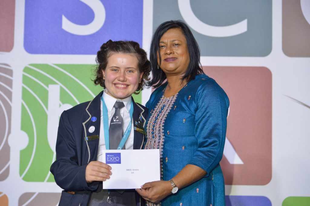 Dr Krishnie Naidoo oorhandig Zachary du Toit haar eerste plek sertifikaat by die Eskom Expo.