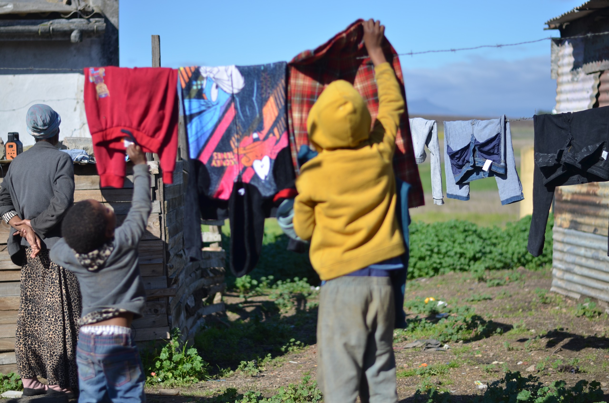 Twee seuntjies hang in Julie vanjaar hul wasgoed op die plaas Ou Ruigtevlei buite Wellington op. Foto: Rasaad Adams