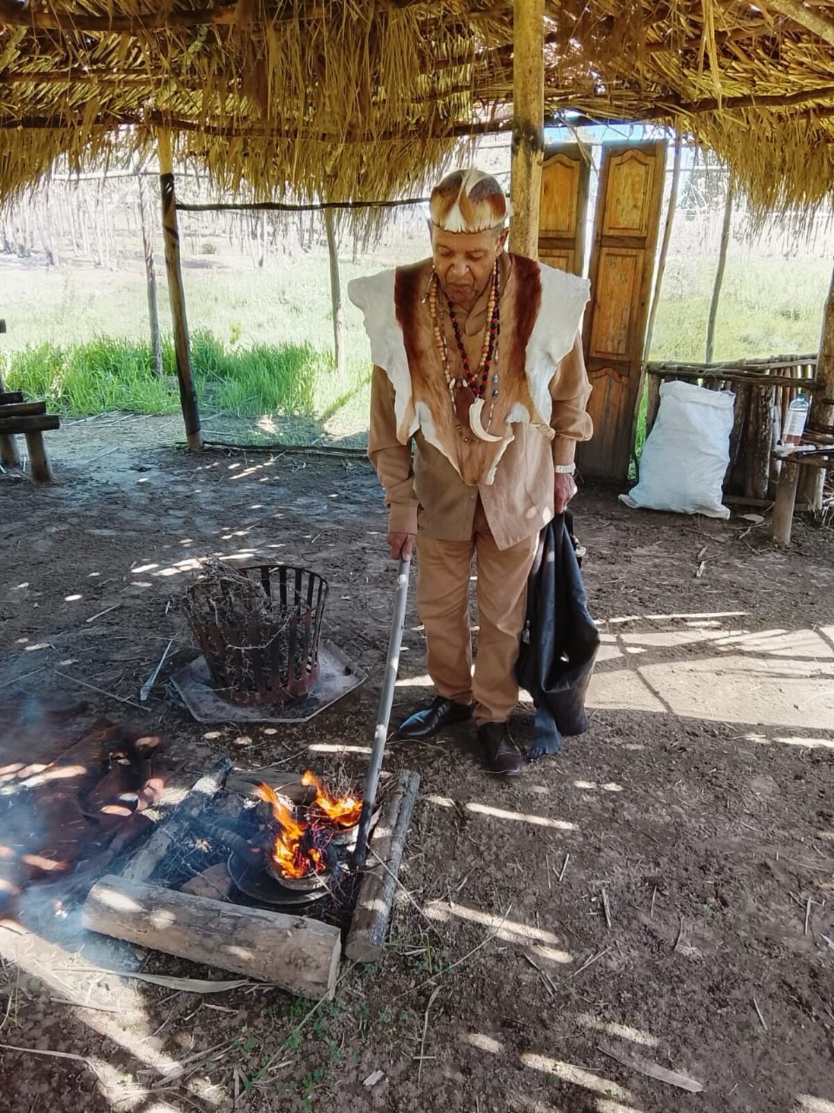Michael van Rooyen burns hotnotsgooigoed (Sage) in a firepit inside a sacred hut which the Khoisan community says the City later tore down.