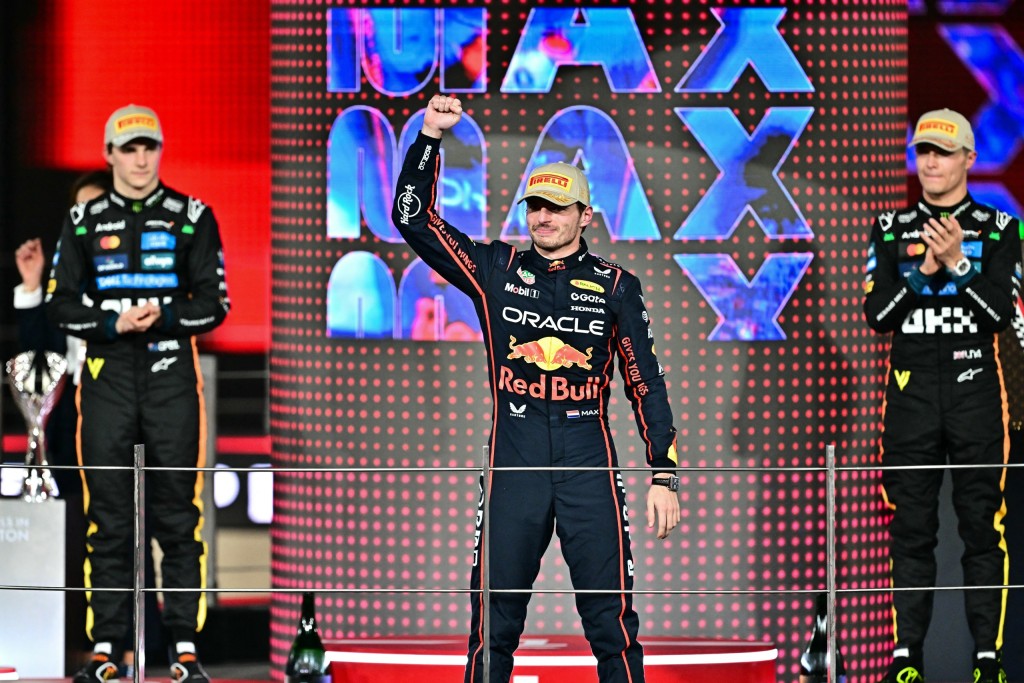 Lando Norris and Oscar Piastri  watch race winner Max Verstappen celebrate.