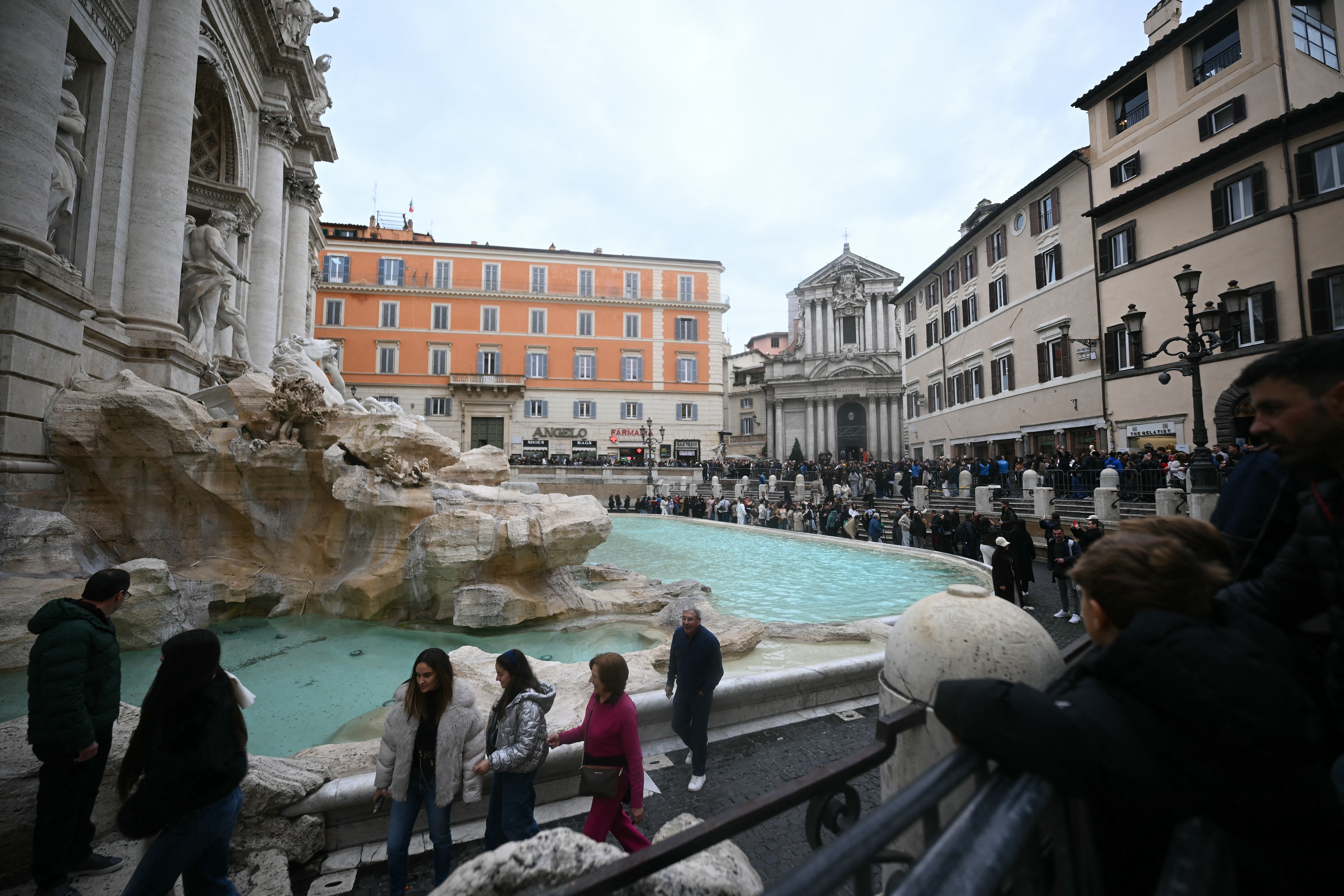 Tourists walk around the Trevi fountain in central Rome. PHOTO: AFP