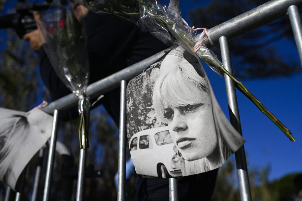 Portraits of late French actress Brigitte Bardot and flowers are displayed on barriers at the entrance of her "La Madrague" house in Saint-Tropez, shortly after her death was announced. PHOTO: Frederic Dides / AFP
