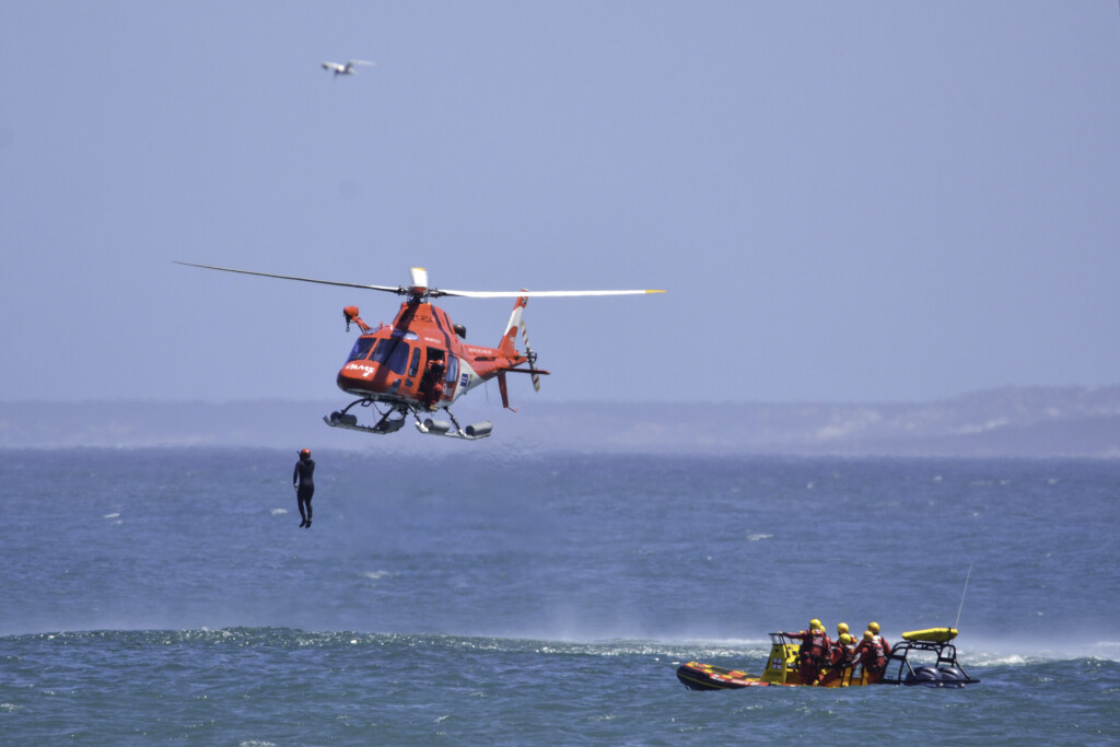 A rescue swimmer steps from the AMS rescue helicopter during the joint training exercise.