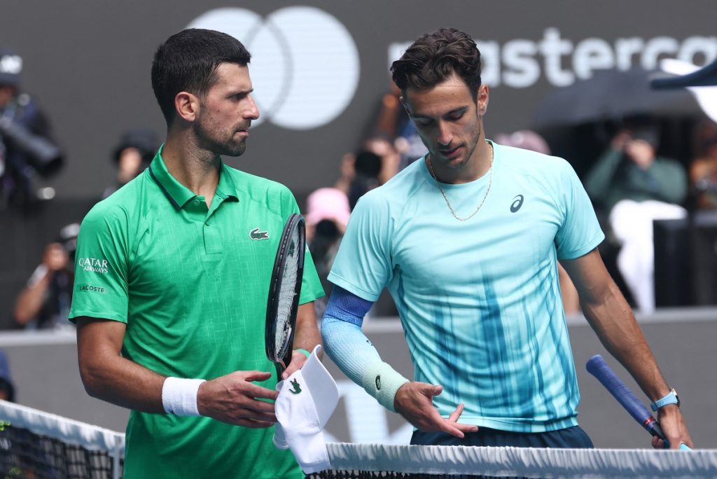 Italy’s Lorenzo Musetti (right) walks off the court with Serbia’s Novak Djokovic.
