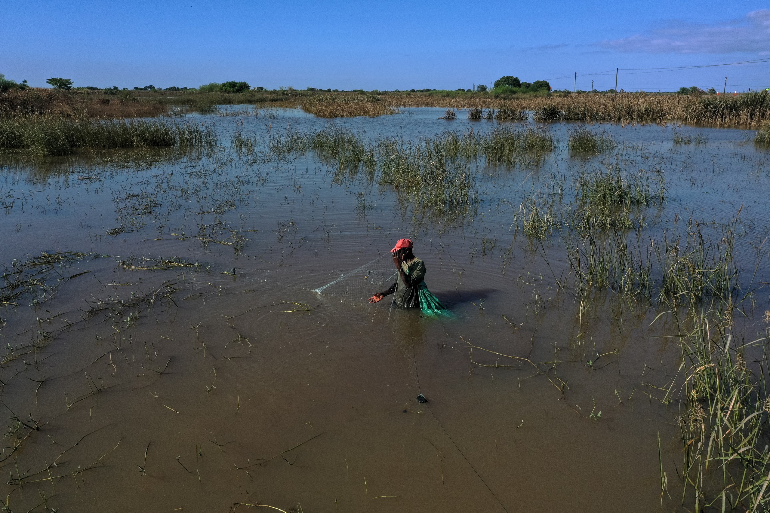 A man fishes in floodwater in the middle of crops and a sugarcane field near 3 De Fevereiro, Mozambique, on Tuesday 27 January. Nearly 140 people have died in the latest floods since October last year, with around 100 000 of the 650 000 people affected sheltering in temporary accommodation centres. Photo: Emidio Jozine / AFP