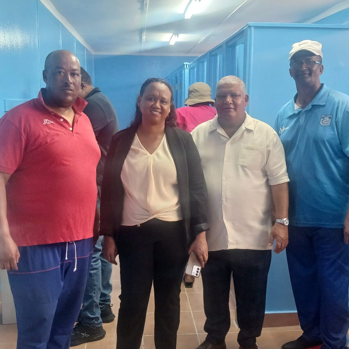 A group of people standing in the newly renovated bathroom.