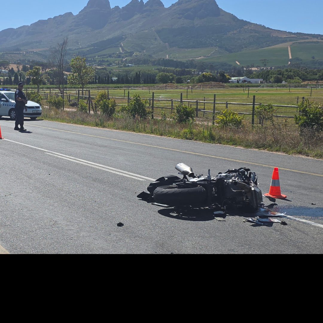 Damaged black BMW motorcycle in road after fatal collision that killed 32-year-old rider in Somerset West