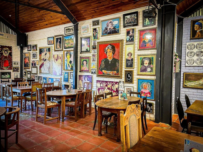 As hierdie mure kon praat, sou hulle waarskynlik hul oë rol, vir jou ’n brandewyn inskink en sê jy moet ophou om jouself so ernstig opneem. Evita se Perron – Darling se beroemdste voormalige treinstasie en Suid-Afrika se 'stoutste' kulturele baken – vier immers die groot 3-0, en die enigste reël vir die viering is: geen vervelige oomblikke toegelaat nie.
Eendag het ’n stowwerige klein treinstasie in Darling verlate gestaan, met die spoke van ou reise wat deur die krake gesug het. Toe kom Pieter-Dirk Uys, die nasie se koning(in) van satire, gewapen met lipstiffie, vernuf en ’n vasberadenheid om alle Suid-Afrikaners te leer lag (en terselfdertyd te dink). Die legendariese satirikus het ook verlede jaar sy 80ste verjaardag gevier.