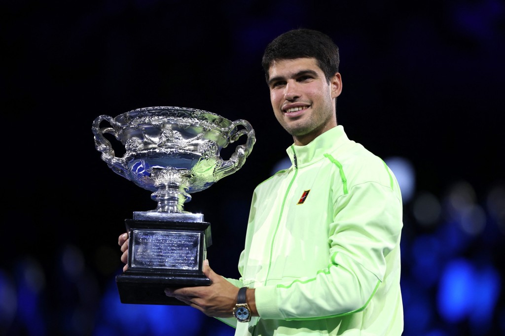 Carlos Alcaraz poses with the Norman Brookes Challenge Cup after defeating Serbia’s Novak Djokovic in the men’s singles final of the Australian Open tennis tournament in Melbourne on February 1, 2026. (Photo by Martin KEEP / AFP