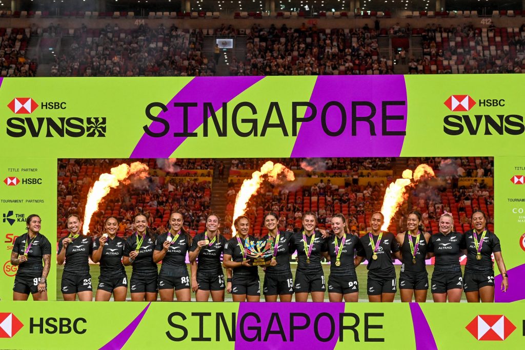 New Zealand team celebrates with the trophy after winning against South Africa at the women's final event during the HSBC Rugby Sevens Singapore tournament in the National Stadium of Singapore on February 1, 2026. (Photo by Roslan RAHMAN / AFP)