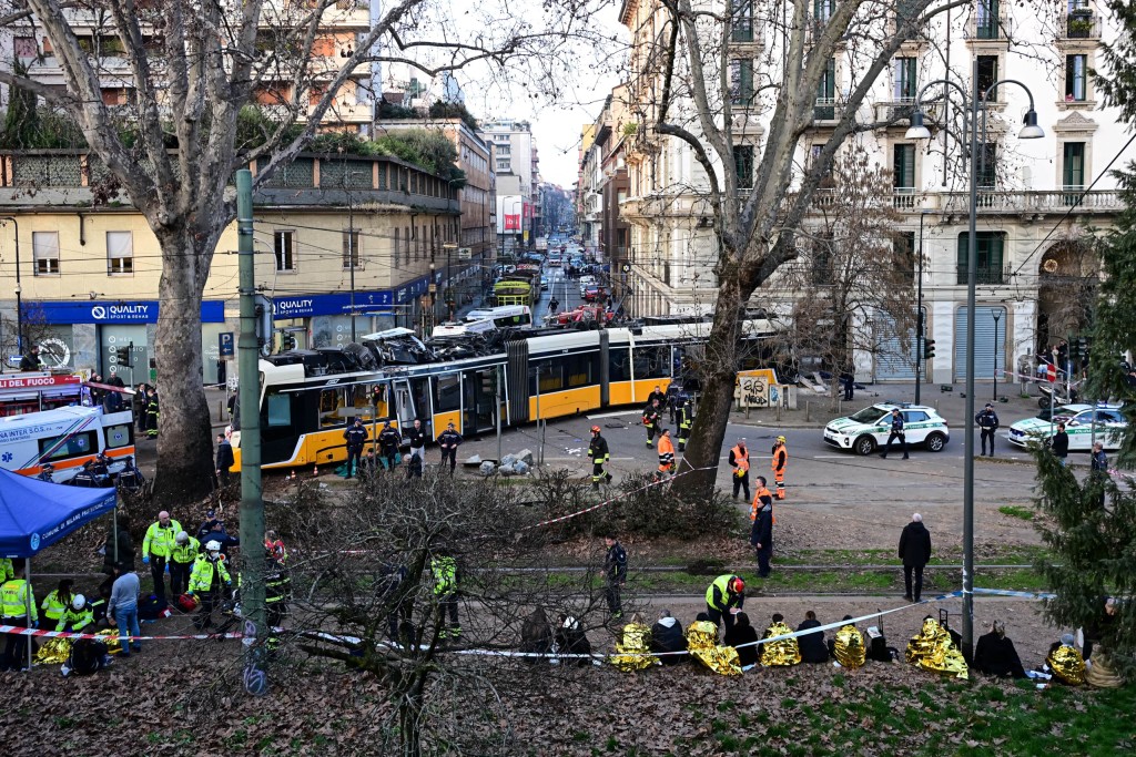 Emergency services teams take care of victims at the site of a tram derailment in Milan. Photo: Piero Cruciatti / AFP
