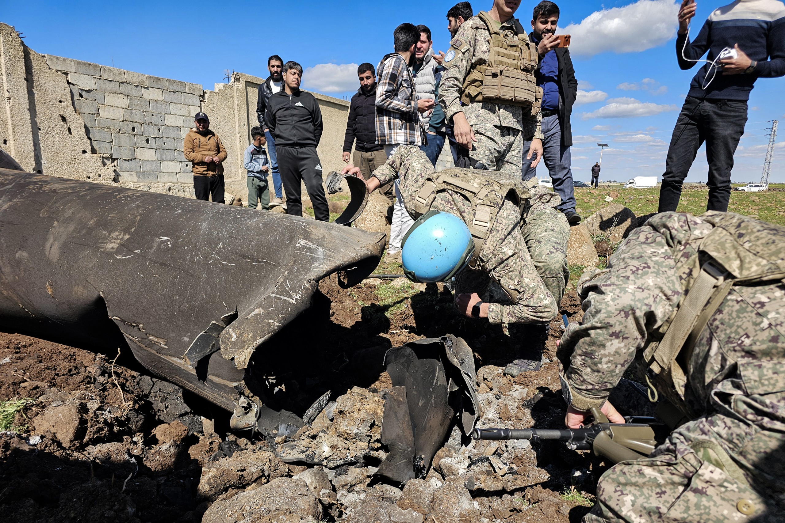 United Nations peacekeepers inspect the wreckage of an Iranian rocket that was reportedly intercepted by Israeli forces in the southern Syrian countryside of Quneitra, near the Golan Heights, close to the town of Ghadir al-Bustan. Photo: Bakr Alkasem / AFP
