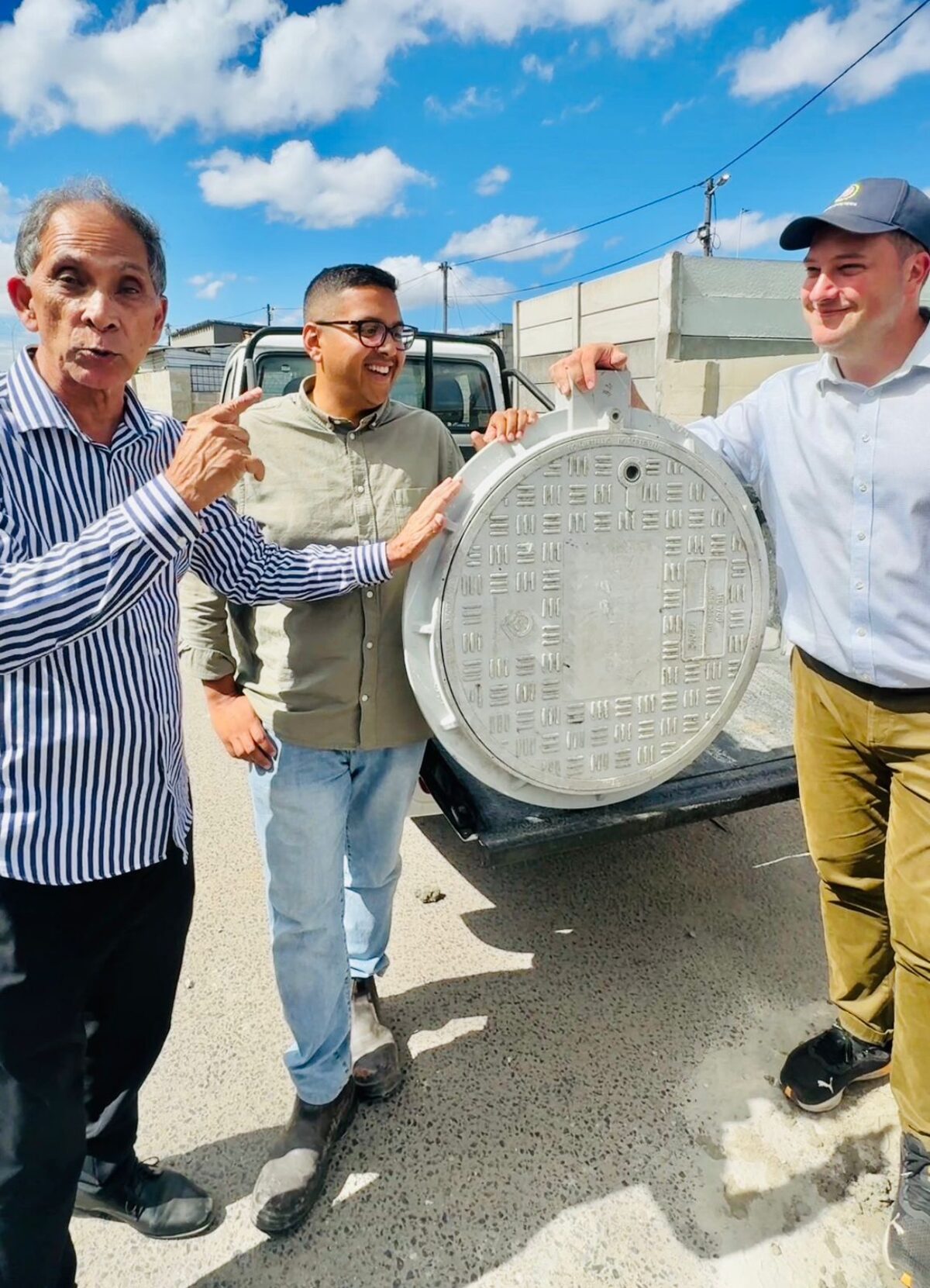 Ebrahim Sawant (wyksraadslid), Zahid Badroodien (burgemeesterkomiteelid: water en sanitasie) en burgemeester Geordin Hill-Lewis met een van die nuwe sluitbare dreindeksels wat gister in Wesbank ingesit is.