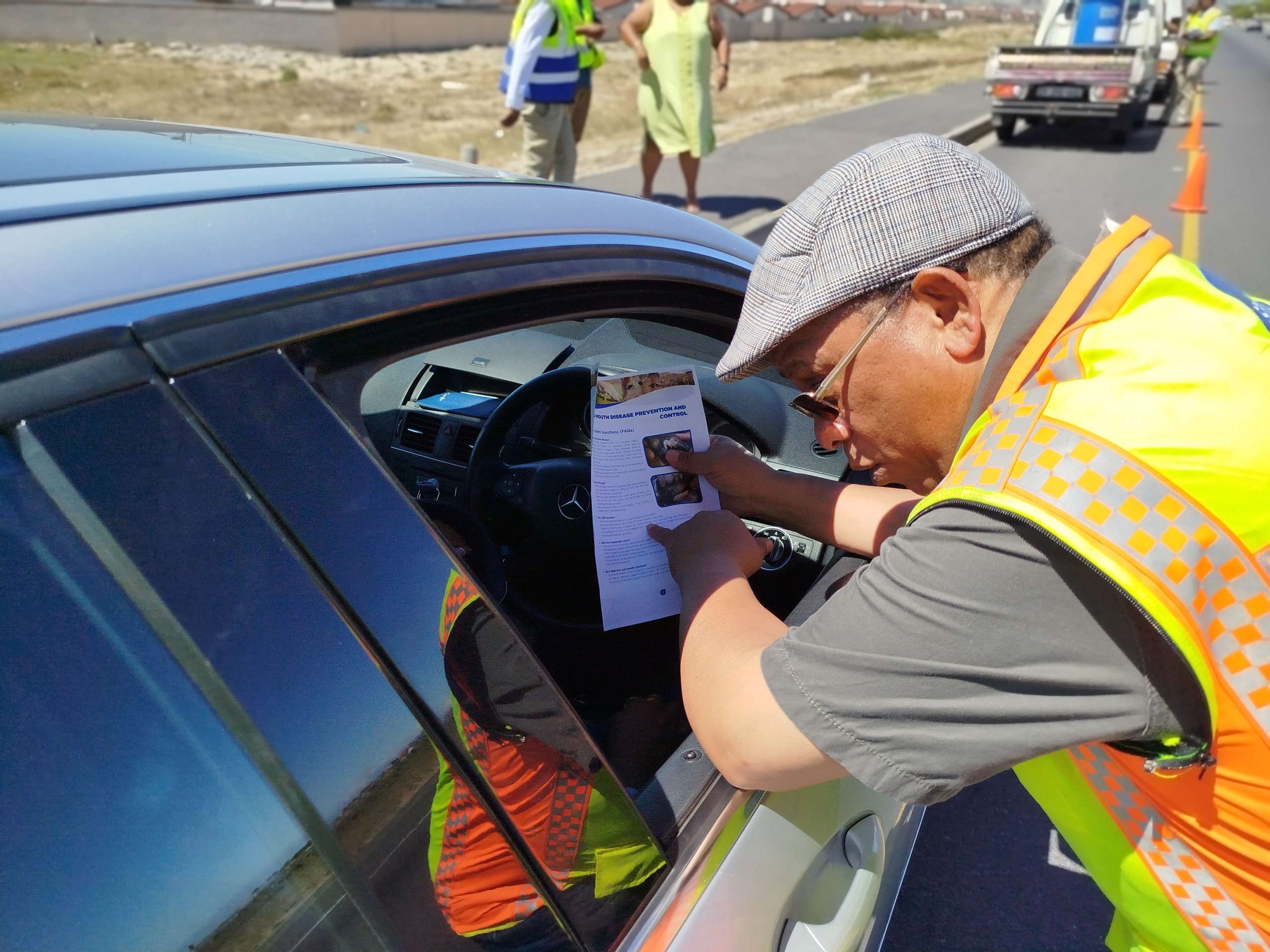 Dr Ivan Meyer speaking to motorists at a traffic control point on a Stellenbosch arterial road, providing information on Foot-and-Mouth Disease (FMD).