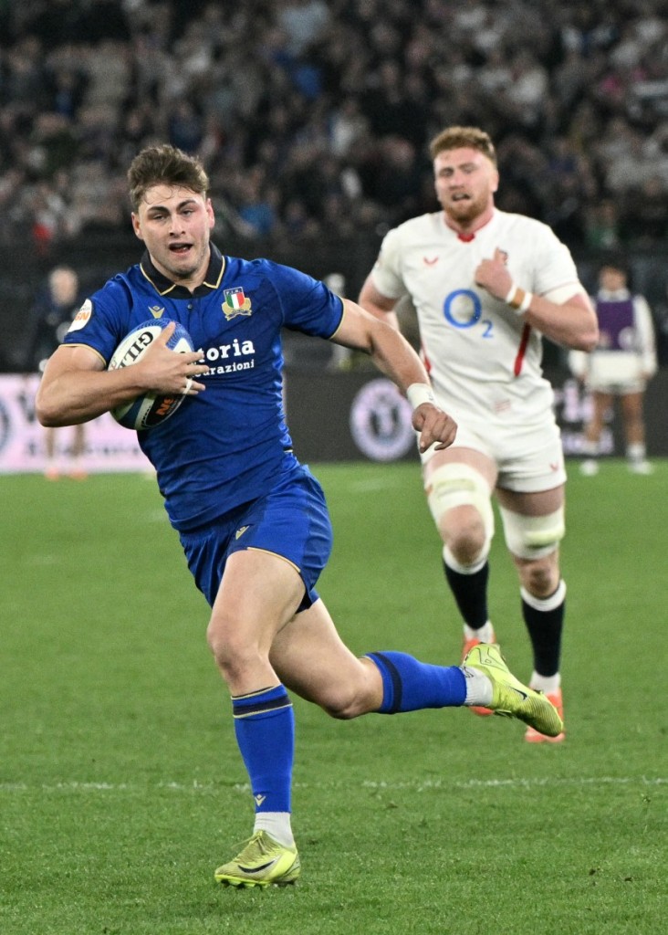 Italy's centre Leonardo Marin (L) runs with the ball to score a try 