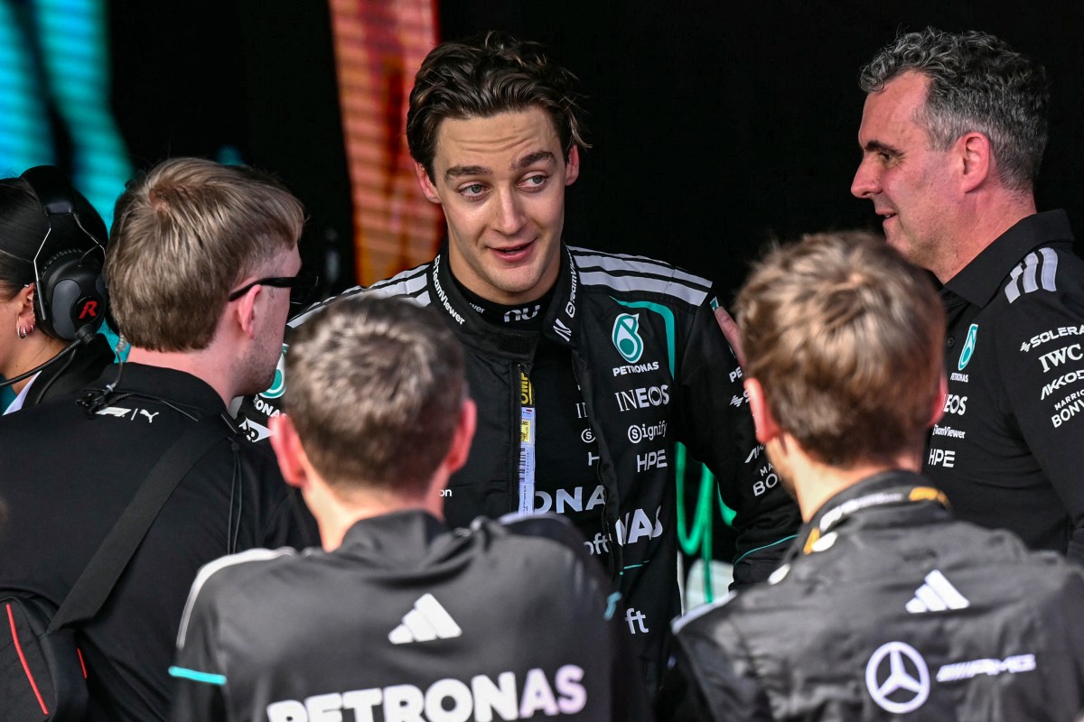 Mercedes' British driver George Russell (C) talks with team members as he celebrates winning the Formula One Australian Grand Prix
