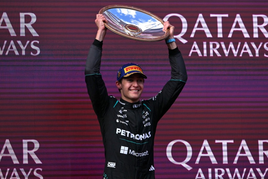 Mercedes' British driver George Russell celebrates on the podium after winning the Formula One Australian Grand Prix 