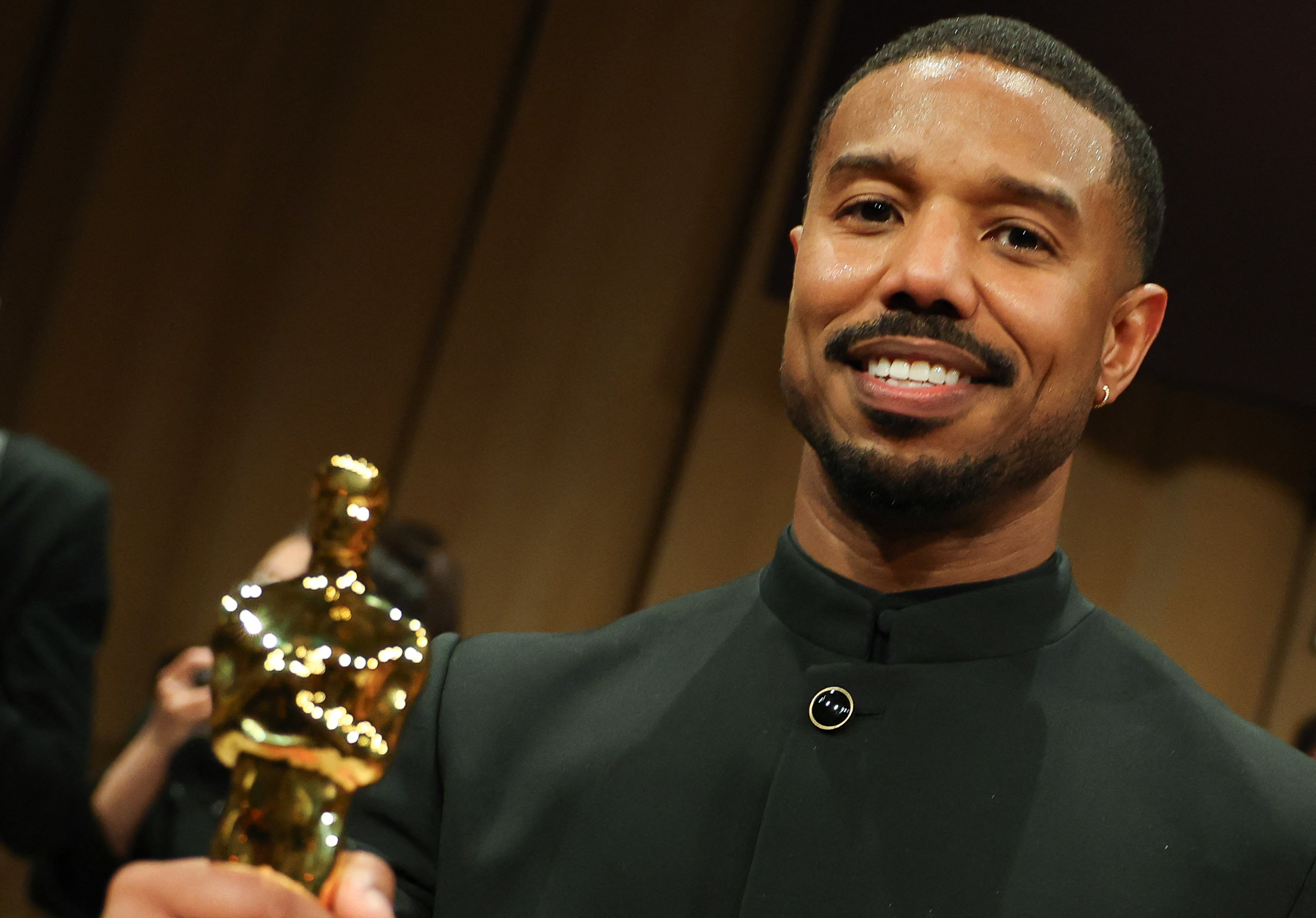 Michael B Jordan holds his Oscar for best actor.