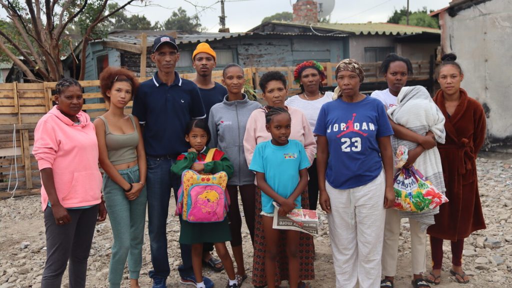 Brandslagoffers staan tussen puin waar hulle huise vroeër gestaan het.