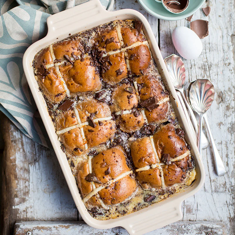 For dessert, leftover hot cross buns are transformed into this decadent warm pudding that serves six. Created by recipe developer Ilse van der Merwe, the dish layers halved hot cross buns with a custard mixture and dark chocolate.