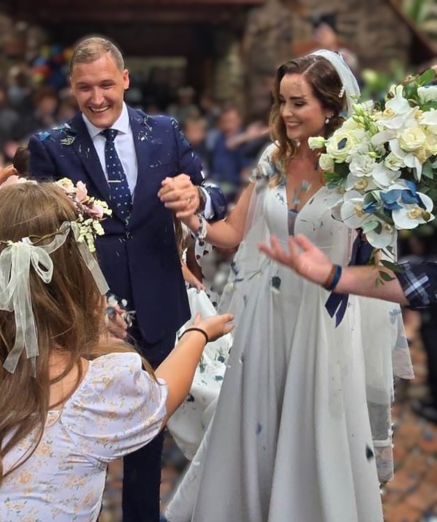 Kinders gooi hande vol blou blare-konfettie op die troupaartjie. FOTO: Michael Hetzel