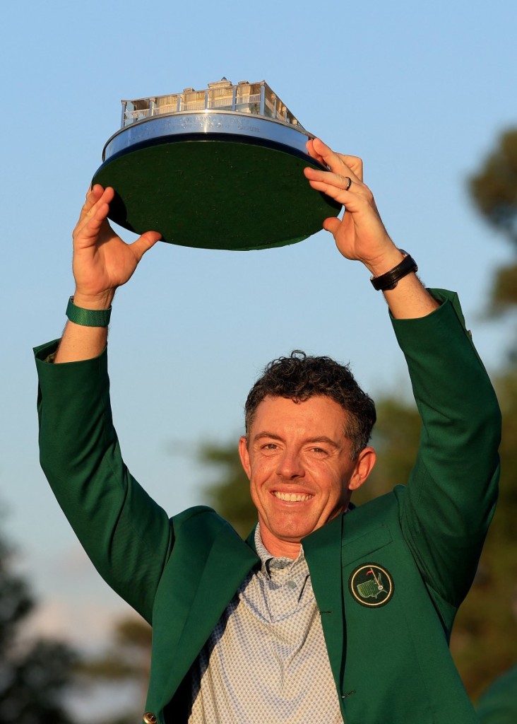 Rory McIlroy of Northern Ireland holds the trophy wearing his Green Jacket at the presentation after the final round of the 2026 Masters