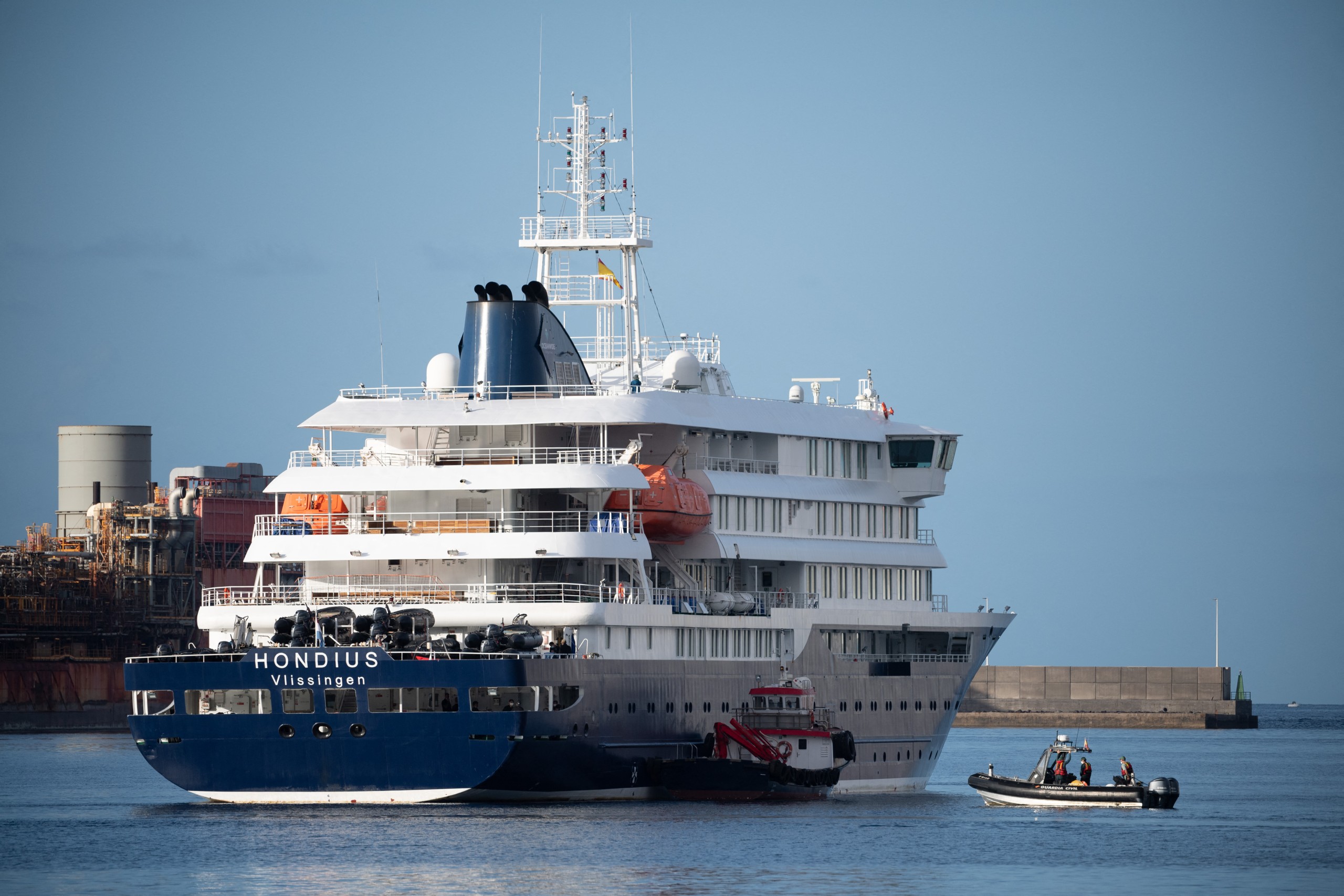 Boats approach the Dutch-flagged hantavirus-stricken cruise ship.