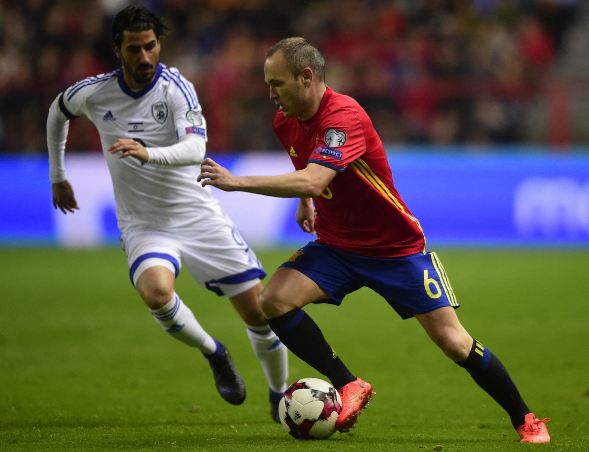 Spain's midfielder Andres Iniesta (R) vies with Israel's midfielder Lior Refaelov during the WC 2018