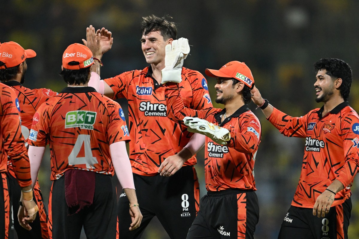 Sunrisers Hyderabad's Australian cricket player Pat Cummins (C) celebrates with teammates after taking the wicket