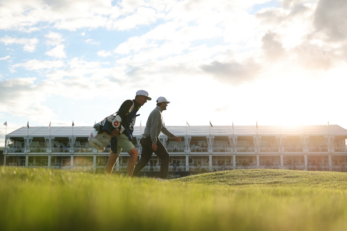Scottie Scheffler of the United States and caddie Ted Scott walk the 17th hole during the first round of the PGA Championship at Aronimink Golf Club
