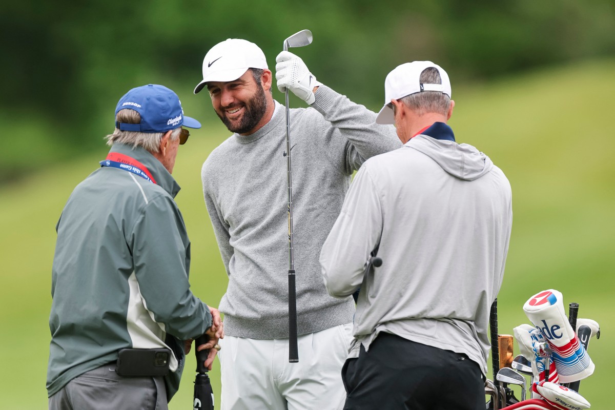 Scottie Scheffler of the United States talks with caddie Ted Scott and swing coach Randy Smith during a practice round