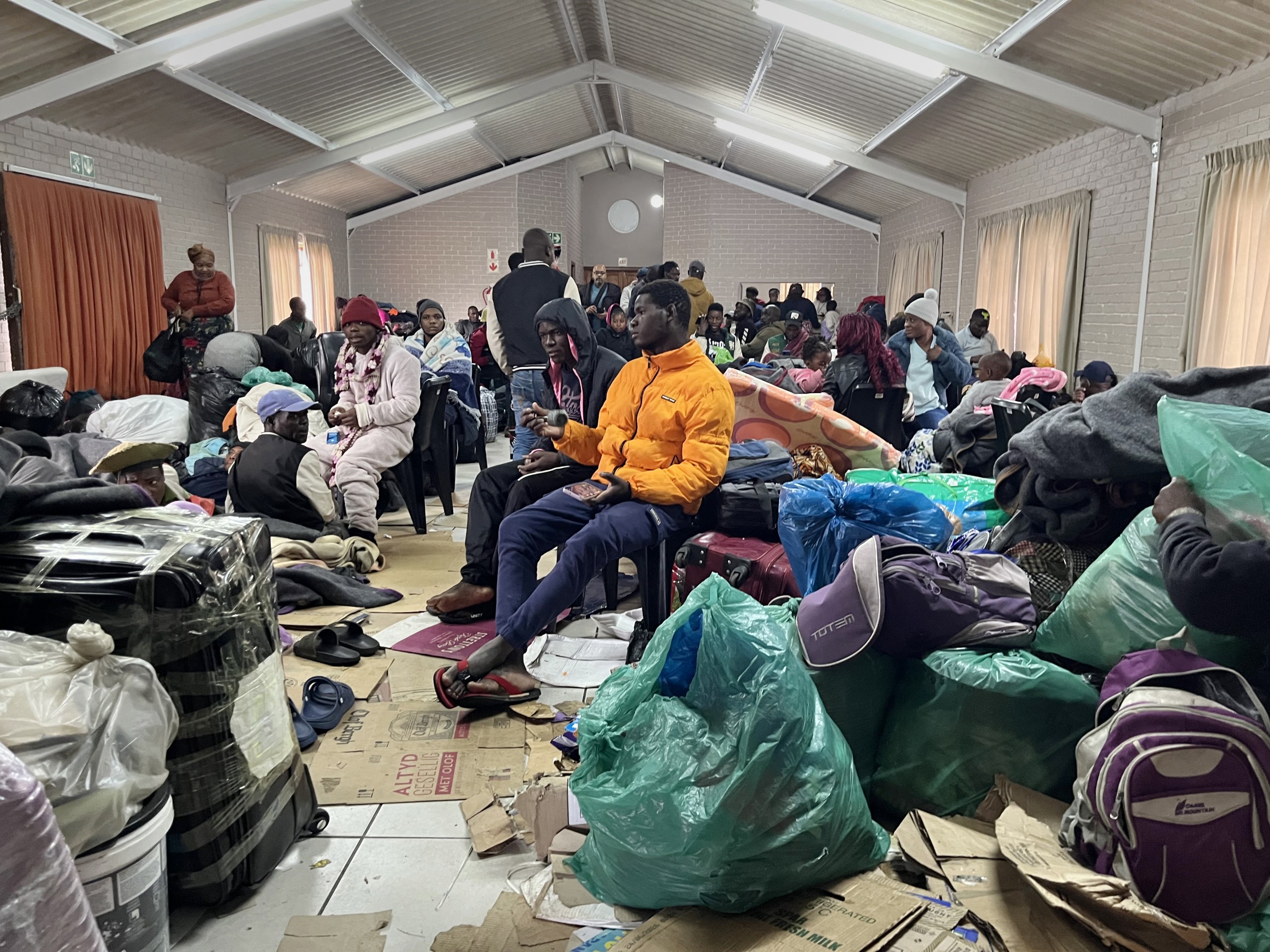 Foreign nationals shelter in a community hall in Mossel Bay on Thursday 4 June 2026, after fleeing anti-migrant violence that left two Mozambicans dead and 55 homes destroyed. Photo: Rodger Bosch/AFP