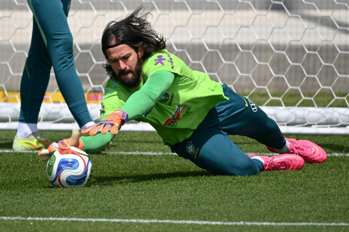 Brazil's goalkeeper Alisson dives for a ball during a training session as part of the team's preparation for its FIFA World Cup football tournament opening match against Morocco.