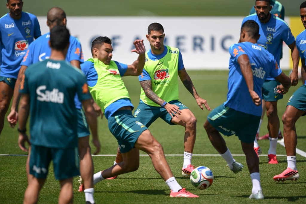 Brazil's midfielders Casemiro (left) and Bruno Guimaraes (middle) fight for the ball.