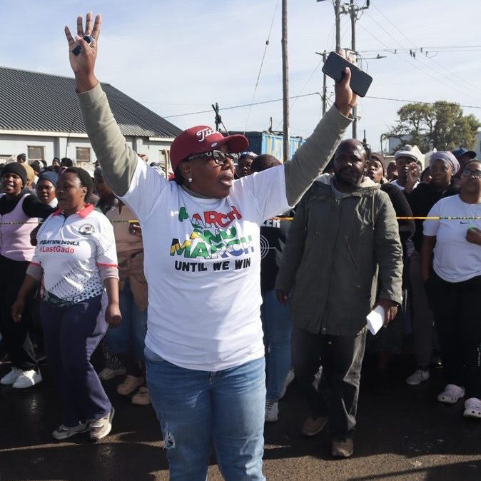 Abigail Nandiloha Matolong directs the crowd in Lwandle in her March and March T-shirt.