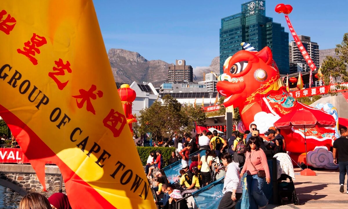 Red lanterns, a towering inflatable dragon, and the flag of the Cape Town Chinese arts group set a festive scene at Battery Park during the 4th "Cultures of China – Cape Town Dragon Boat Festival".