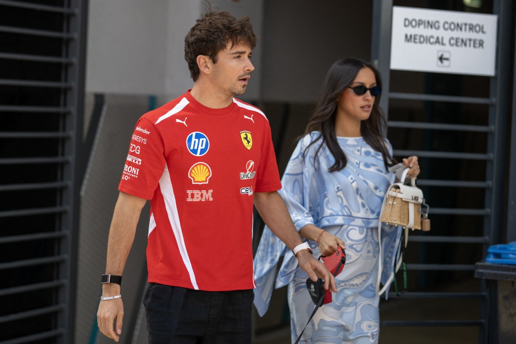 Ferrari's Monegasque driver Charles Leclerc and his wife Alexandra Leclerc walk in the paddock prior the first practice session at the Hungaroring racetrack